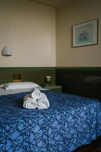 a hotel room with a bed with towels on it at Hotel Royal in Fermo