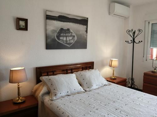 トレモリノスにあるApartamento Carihuela Playaのベッドルーム1室(ランプ2つ、写真付)