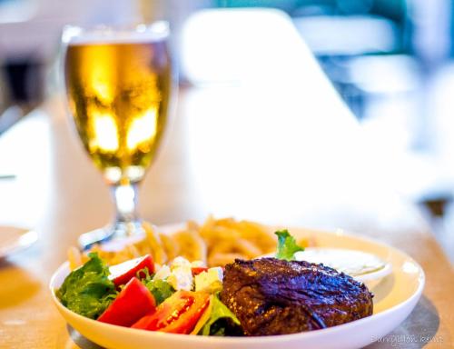 a plate of food and a glass of beer at Sky Island Resort in Ponta Malongane
