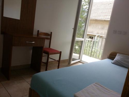 a bedroom with a bed and a desk and a window at Apartments Montenegro Risan Čučković in Risan