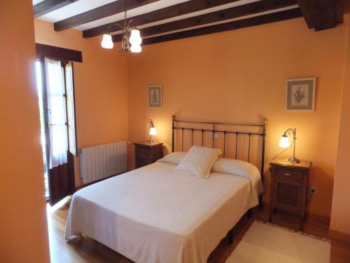 a bedroom with a white bed and two night stands at Posada La Pedriza in Pontones