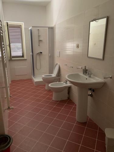 een badkamer met een toilet, een wastafel en een douche bij Stanza vacanza lo stadio in Sibari