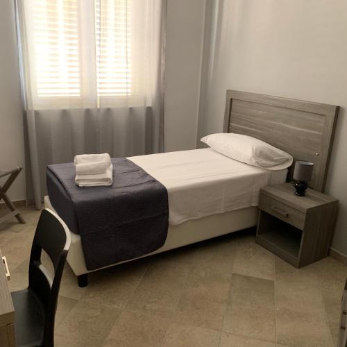 a small bedroom with a bed and a chair at Stanza vacanza lo stadio in Sibari