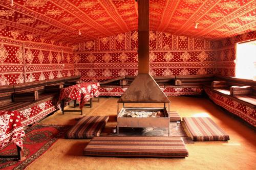 a room with a stove in the middle of a room at Wadirum sunrise camp in Wadi Rum