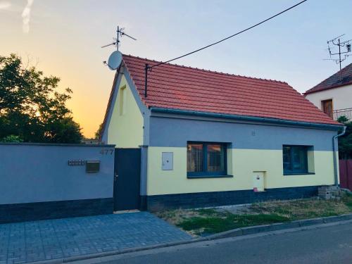 une petite maison blanche avec un toit rouge dans l'établissement Ubytování V Zátiší Lednice, à Lednice