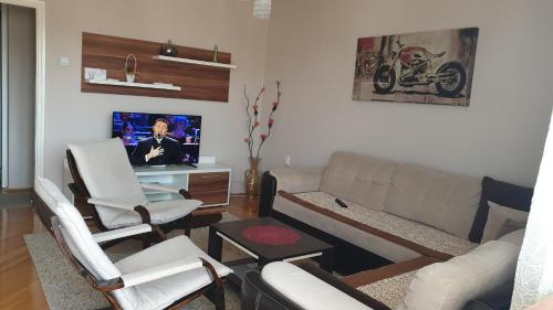 a living room with a couch and a tv at Apartman Sweet dreams 1 in Niš