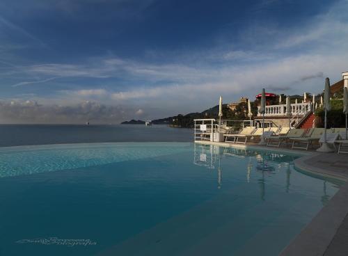 a large swimming pool with a view of the water at Excelsior Palace Portofino Coast in Rapallo