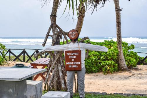 a man standing on the beach holding a sign at Insight Resort Ahangama - S&S Other Certified in Ahangama