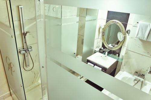 a bathroom with a sink and a mirror at Grand Hotel Continental Bucuresti in Bucharest