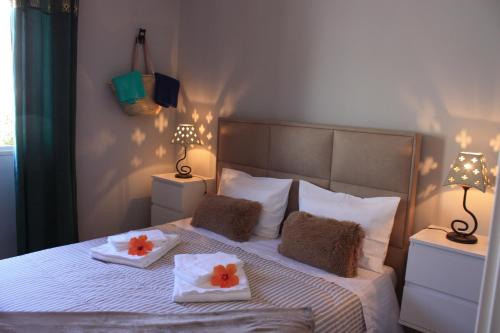 um quarto com uma cama com 2 toalhas e 2 candeeiros em Palmeira em Faro