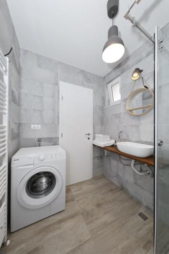 a bathroom with a washing machine and a sink at Apartments Ivanov in Zadar