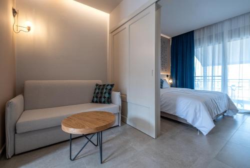 a bedroom with a bed and a couch and a table at ELIXIA in Tolo