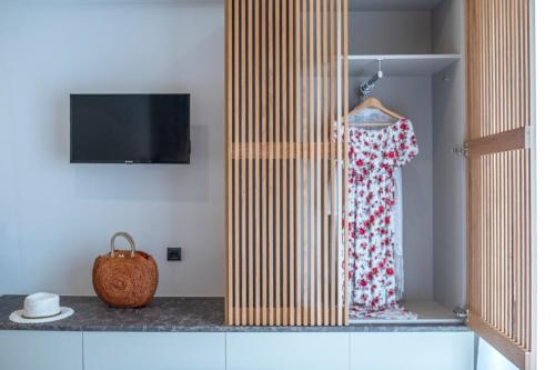 a dress is hanging in a room with a tv at ELIXIA in Tolo