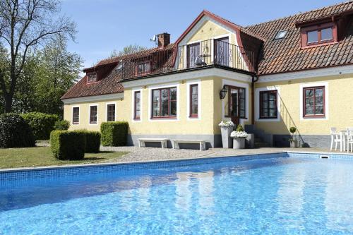 a house with a swimming pool in front of a house at Flädie Mat & Vingård in Flädie