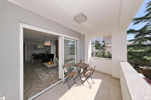 a room with a balcony with chairs and a table at Apartments Ivanov in Zadar