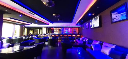 a restaurant with chairs and a bar with purple lights at New Farah Hotel in Agadir