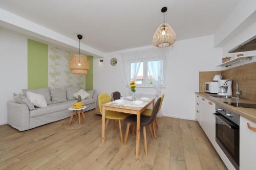 a kitchen and living room with a table and a couch at Apartments Ivanov in Zadar