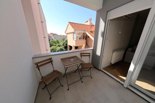 a balcony with three chairs and a counter with a view at Apartments Ivanov in Zadar