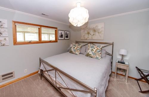 Un dormitorio con una cama y una lámpara de araña. en Small Batch Lodging, en Granville