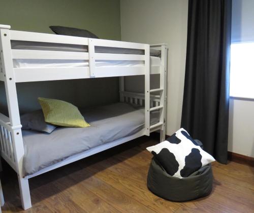 a couple of bunk beds in a room with a cow pillow at Wildwood Apartment in Carlingford