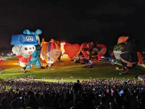 a large crowd of people watching hot air balloons at Ho Hai Yan Homestay in Chenggong