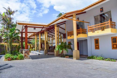 a large white building with a balcony and a courtyard at Insight Resort Ahangama - S&S Other Certified in Ahangama