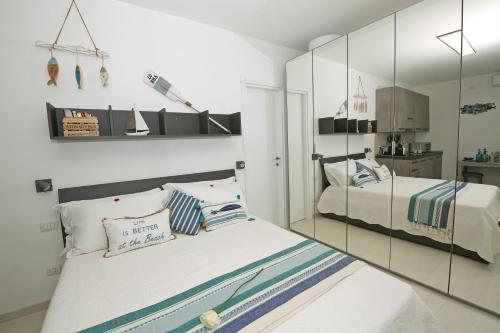 a bedroom with two beds and a mirror at Apartment A lago private beach and parking in Oliveto Lario