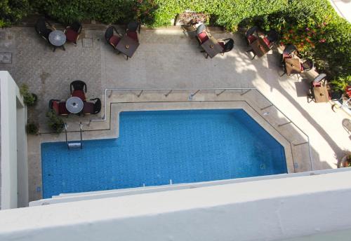 einen Blick über einen Pool mit Liegestühlen in der Unterkunft New Farah Hotel in Agadir