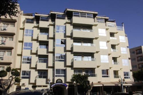 a tall apartment building with windows at New Farah Hotel in Agadir