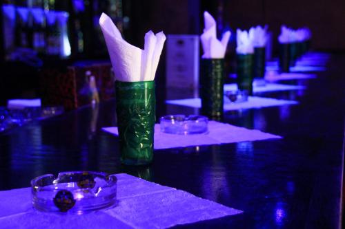 a row of green vases with white napkins on a table at New Farah Hotel in Agadir