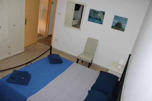 a bedroom with a blue bed and a chair at B&B RoGe in Olbia