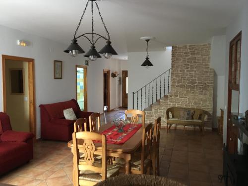 sala de estar con mesa y sofá rojo en Casa Rural Ca-Alzina, en Benimeli