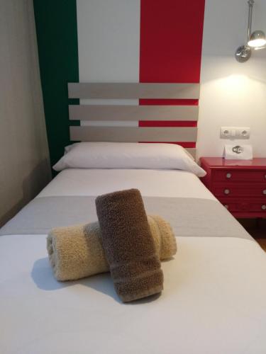 a bedroom with two beds with towels on the bed at PENSION ROSELLA in O Pedrouzo