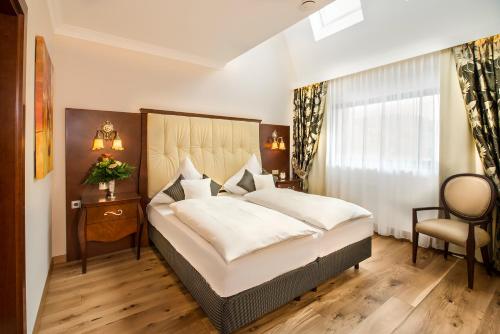 a bedroom with a large bed and a chair at Residence Bellevue in Boppard
