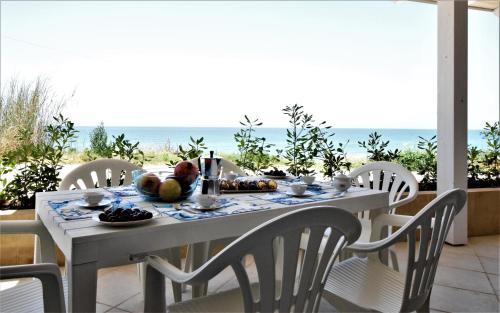 a table with food and the ocean in the background at Covo dei Marinai in Cava dʼAliga