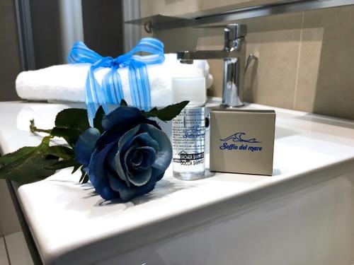 une rose bleue assise au-dessus d'un lavabo dans l'établissement Soffio del mare, à Lido di Fermo