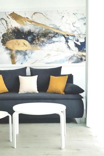 a living room with a blue couch and a white table at WEST RESIDENCE APARTMENTS in Timişoara