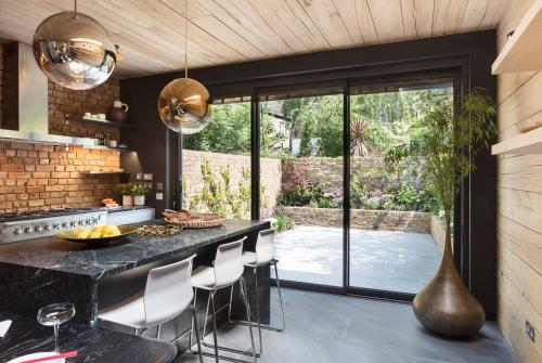 una cucina con bancone nero e sedie di Contemporary Boutique Residence a Londra