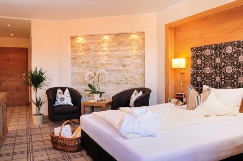 a hotel room with a bed and two chairs at Wellness- & Sporthotel Jagdhof in Röhrnbach