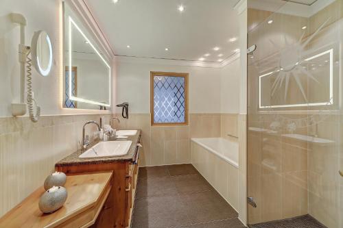 a bathroom with a sink and a shower at Wellness- & Sporthotel Jagdhof in Röhrnbach