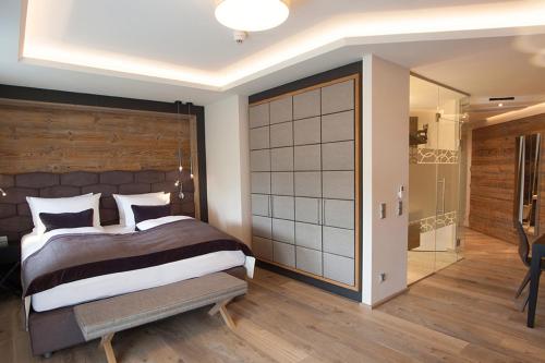 a bedroom with a large bed and a sliding door at Wellness- & Sporthotel Jagdhof in Röhrnbach
