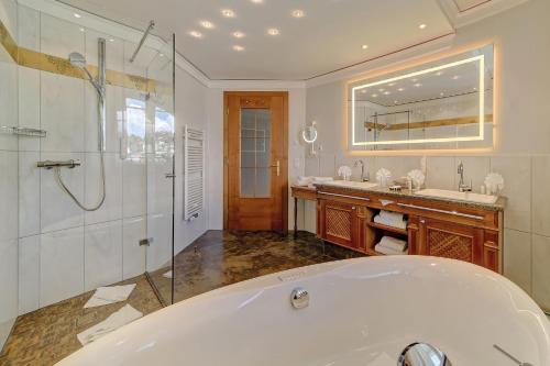 a large bathroom with a tub and a shower at Wellness- & Sporthotel Jagdhof in Röhrnbach