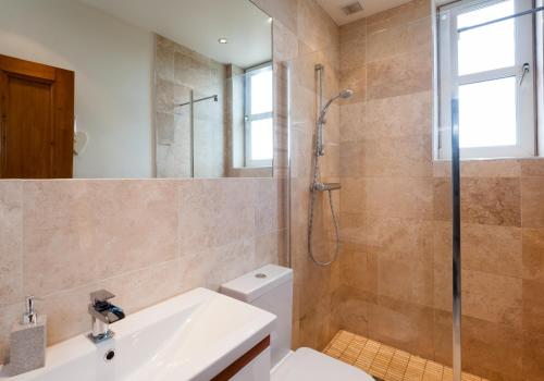 a bathroom with a shower and a toilet and a sink at The Traquair Park Residence in Edinburgh
