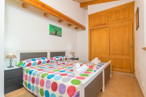 a bedroom with a large bed with a colorful comforter at Can Fabiol - Adults Only in Sóller