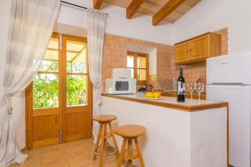 a kitchen with a white refrigerator and a counter with stools at Can Fabiol - Adults Only in Sóller