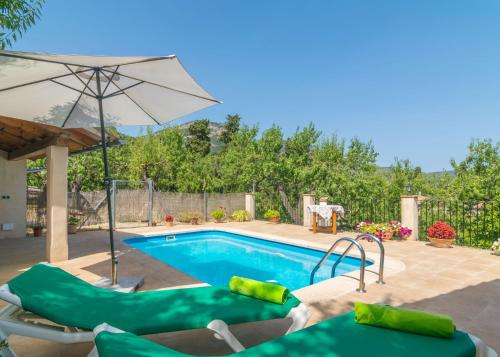 a swimming pool with an umbrella and chairs next to it at Can Fabiol - Adults Only in Sóller