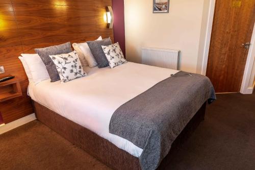 a bedroom with a large bed with pillows at Legacy Preston International Hotel in Preston