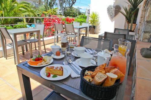 a table with breakfast foods and drinks on a balcony at Hôtel La Villa Cap d’Antibes in Juan-les-Pins