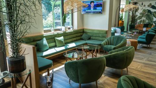 a waiting room with a green couch and chairs at Mercure Niort Marais Poitevin in Niort