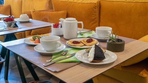 a table with plates of food and cups on it at Mercure Niort Marais Poitevin in Niort